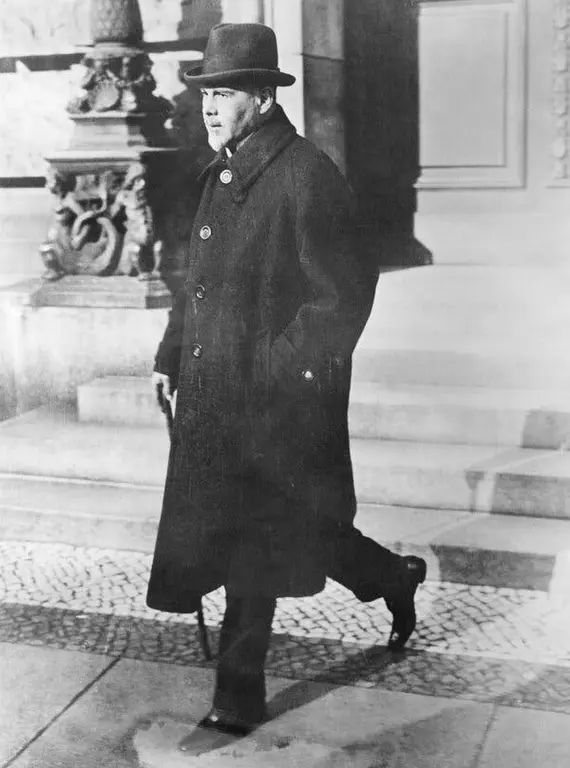 عکس سیاه‌وسفید مردی با ریش و سبیل، در کت و کلاه، والتر راثناو در سال ۱۹۲۲ که در حال پایین رفتن از پله‌ها است.